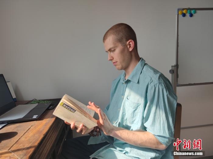 图为4月20日，无名在郑州家中翻阅《黄帝内经》。 中新社记者 阚力 摄