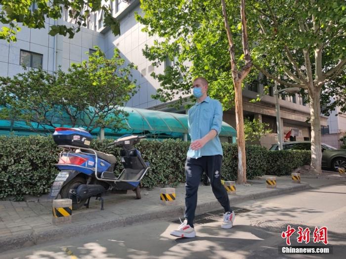 图为4月20日，无名在所住的小区散步。 中新社记者 阚力 摄